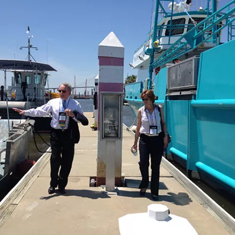 Deputy Director Margaret Schneider and Oil Spill Response Chief David Moore view on-water assets prior to their deployment during the demonstration at the International Oil Spill Conference.