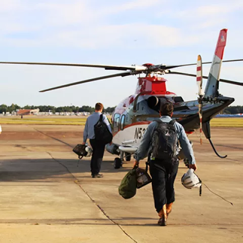 BSEE inspectors walking towards helicopter.